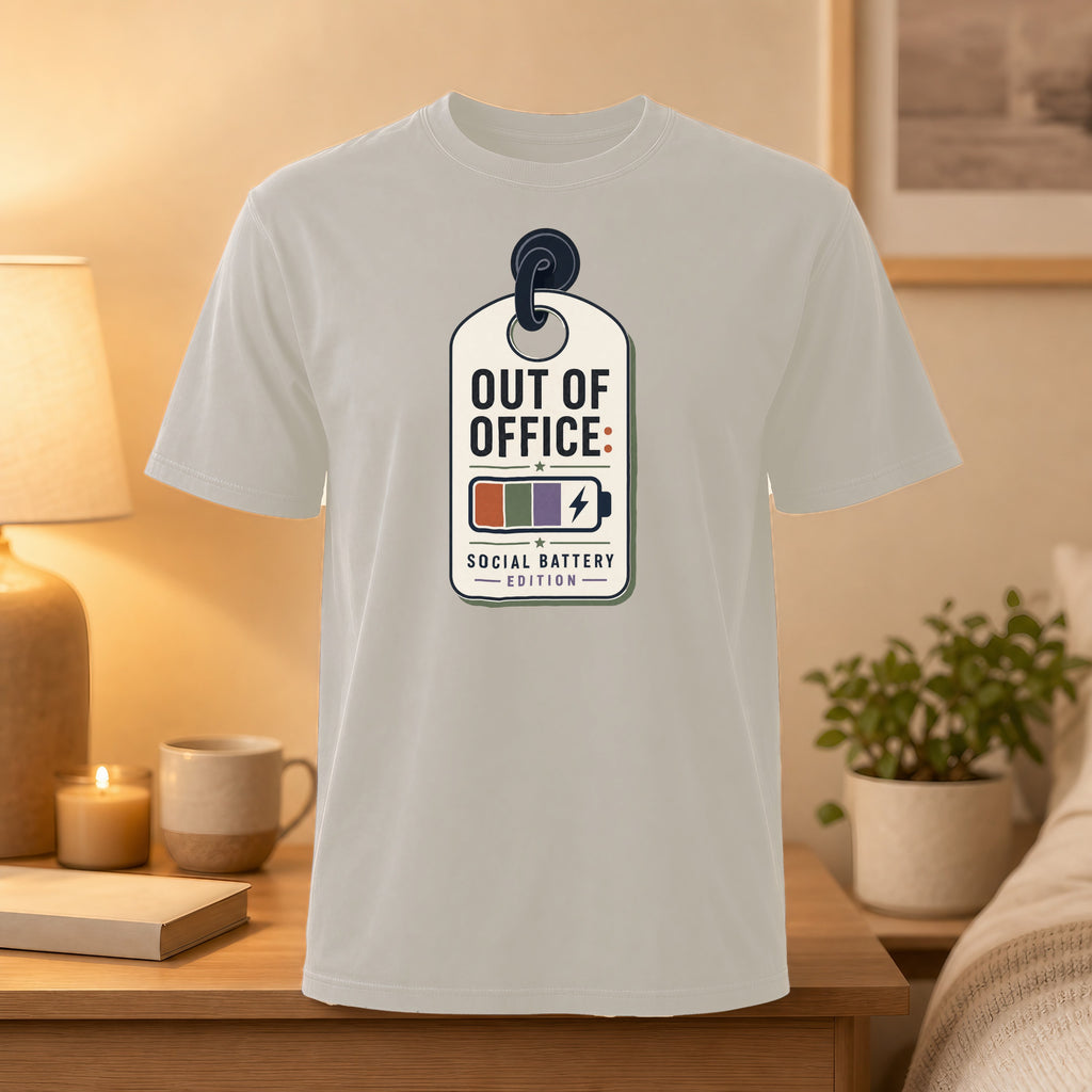 T-shirt featuring "OUT OF OFFICE: SOCIAL BATTERY EDITION" in a tag design with battery icons.