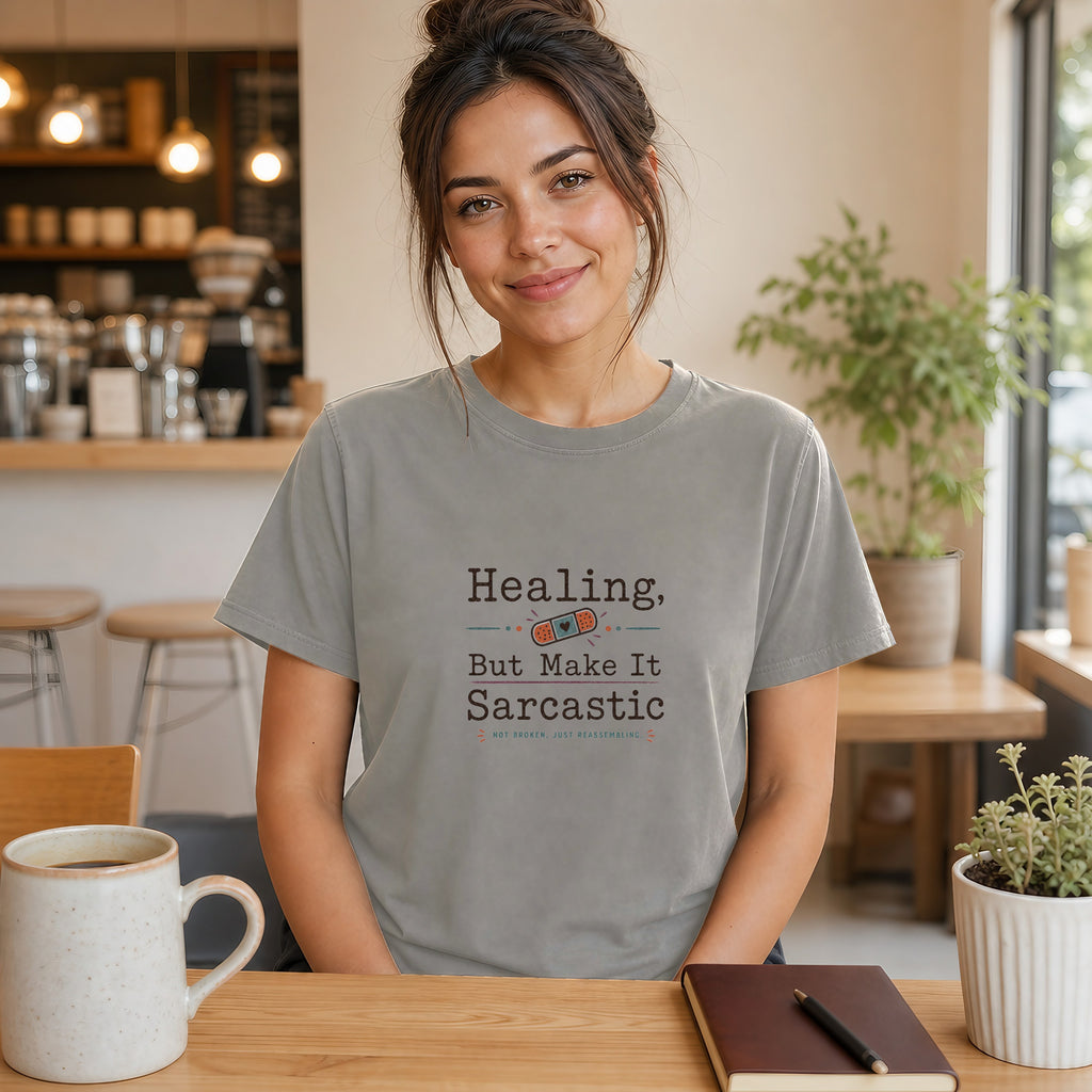 Woman wearing a gray t-shirt with "Healing, but make it sarcastic" text.