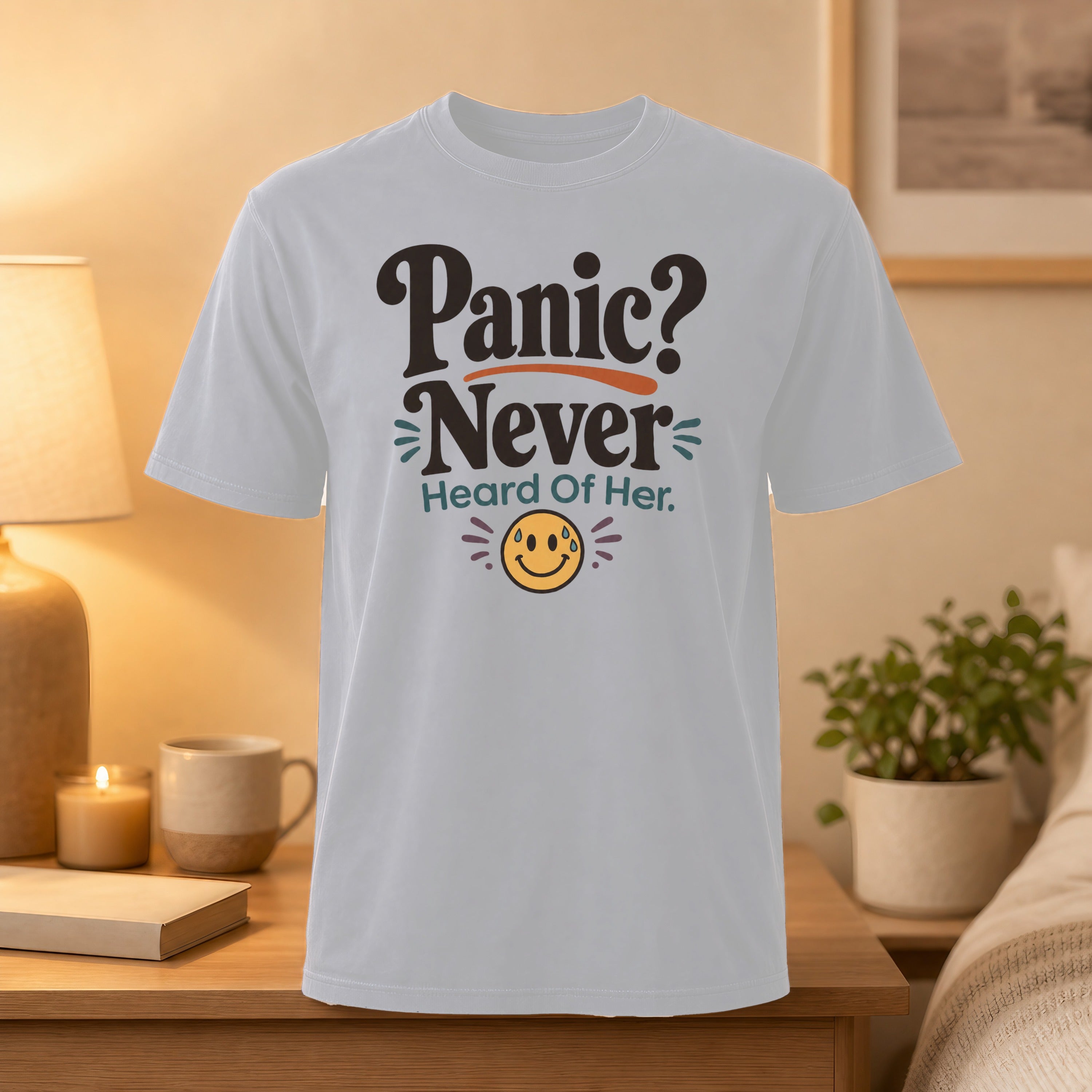 White t-shirt with "Panic? Never Heard Of Her." text and smiling emoji.
