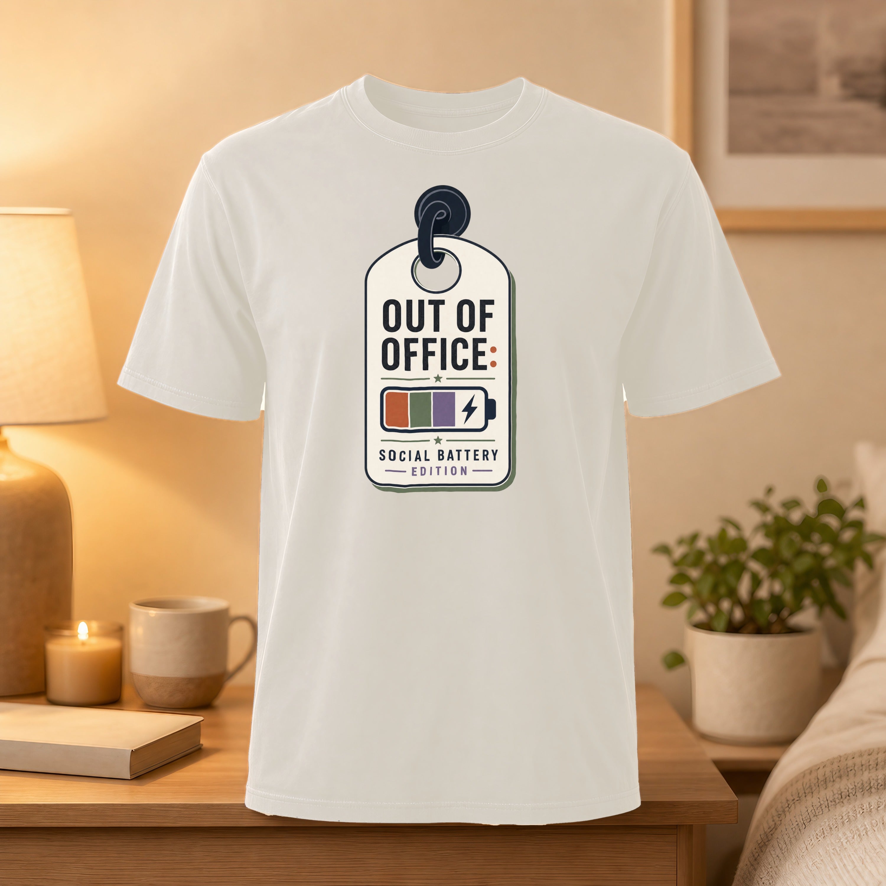 White t-shirt with "Out of Office: Social Battery" graphic on a tag.