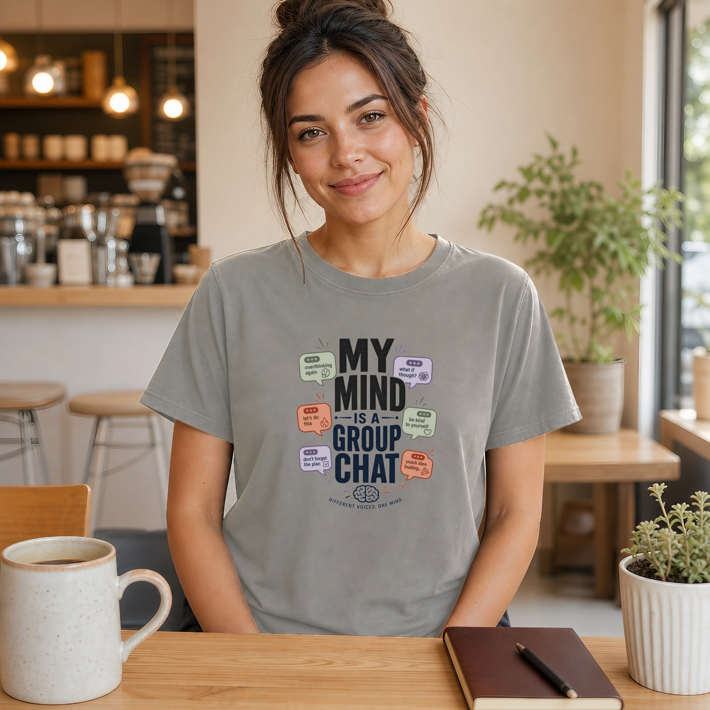 Woman wearing gray t-shirt with "MY MIND IS A GROUP CHAT" text.