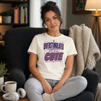 Woman wearing a white t-shirt with "OVERSTIMULATED BUT STILL CUTE" text.