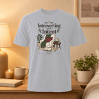 T-shirt with "Introverting With Intent" text and cozy reading nook illustration.